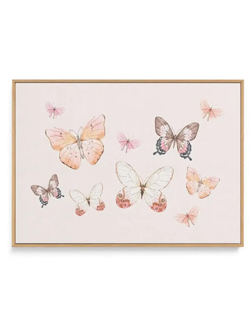 Framed canvas art print featuring a delicate watercolor illustration of various butterflies in shades of blush pink, peach, cream, and taupe scattered across a soft beige background. The composition includes larger detailed butterflies with spotted wing patterns alongside smaller, more minimalist butterfly designs. The canvas is set in a natural wood frame with a white border, creating a soft, bohemian aesthetic against the pale neutral palette.