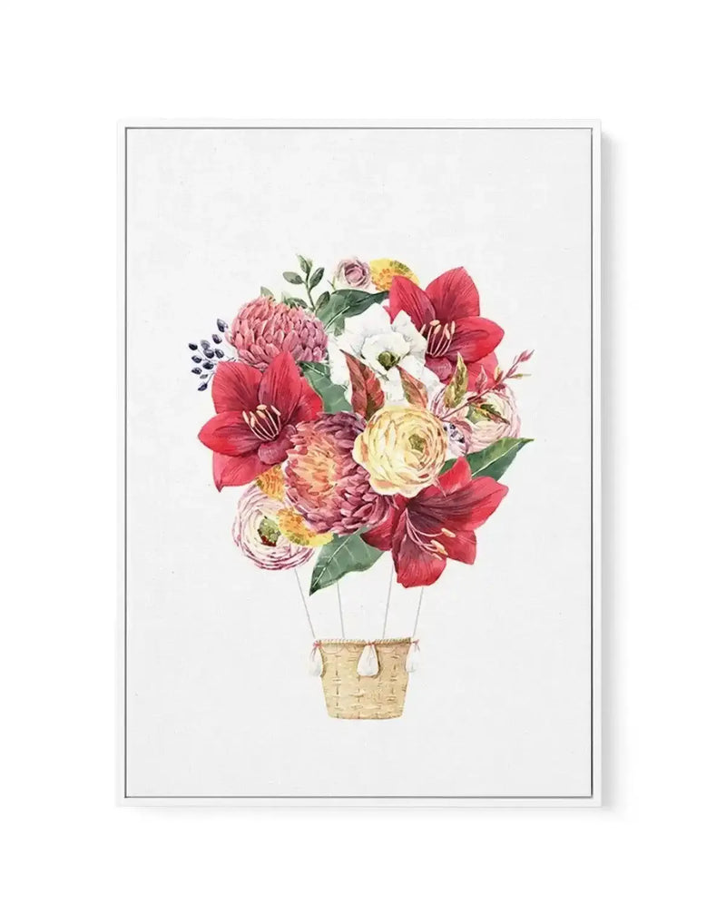 Watercolor illustration of a hot air balloon made entirely of vibrant flowers in shades of red, pink, mauve, cream, and yellow, including peonies, roses, ranunculus, and amaryllis with green foliage. The balloon basket is rendered in woven tan material. The composition is centered on a white background. The artwork is printed on canvas with a gray frame and white border.