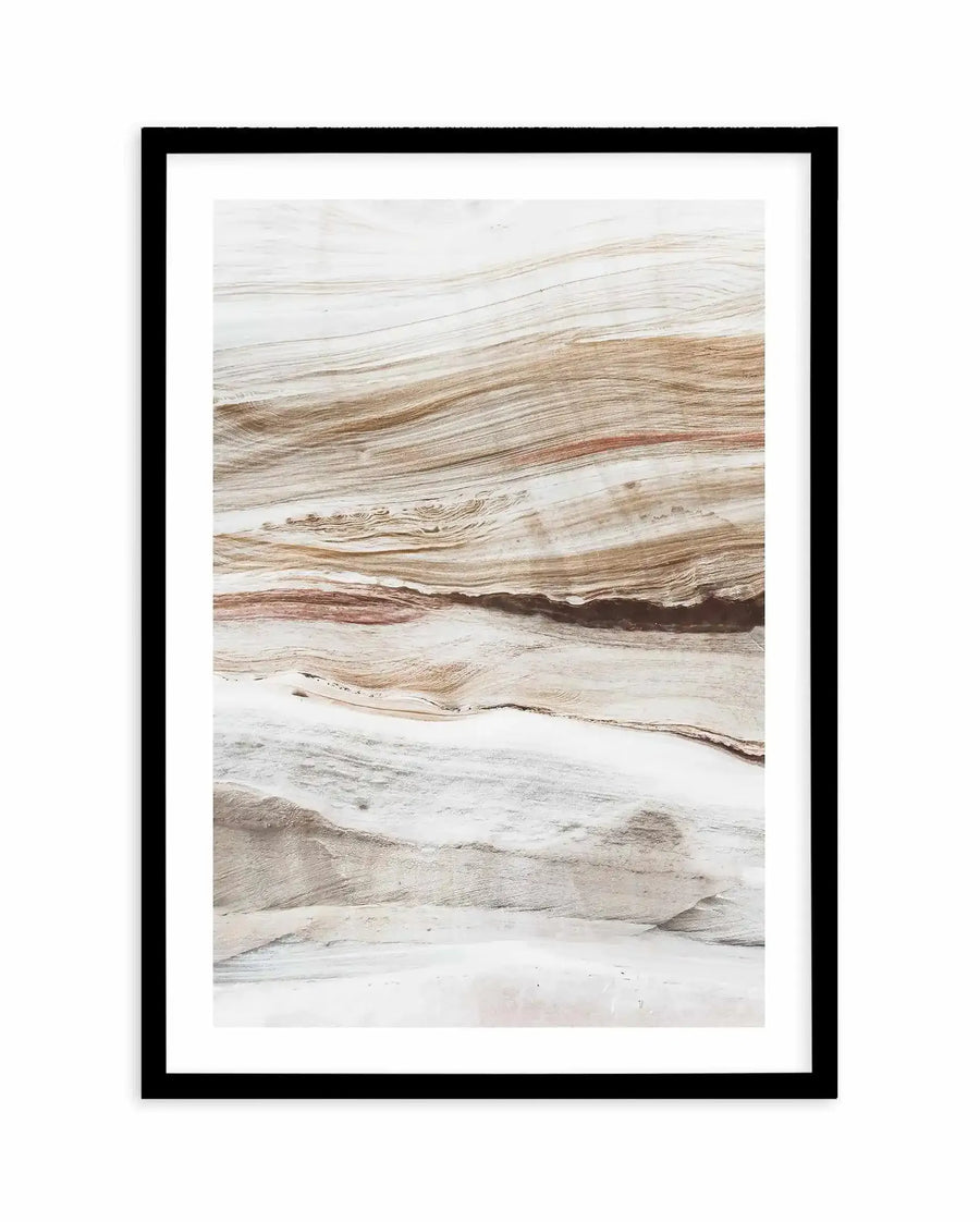 Framed art print titled "Bronte Rocks I" displayed against a white background. The photograph shows layered rock formations with horizontal striations in warm earth tones including tan, beige, cream, and rust red, with areas of white mineral deposits. The natural texture and geological patterns create an abstract, landscape-like composition. The print is presented in a black frame with a white border.