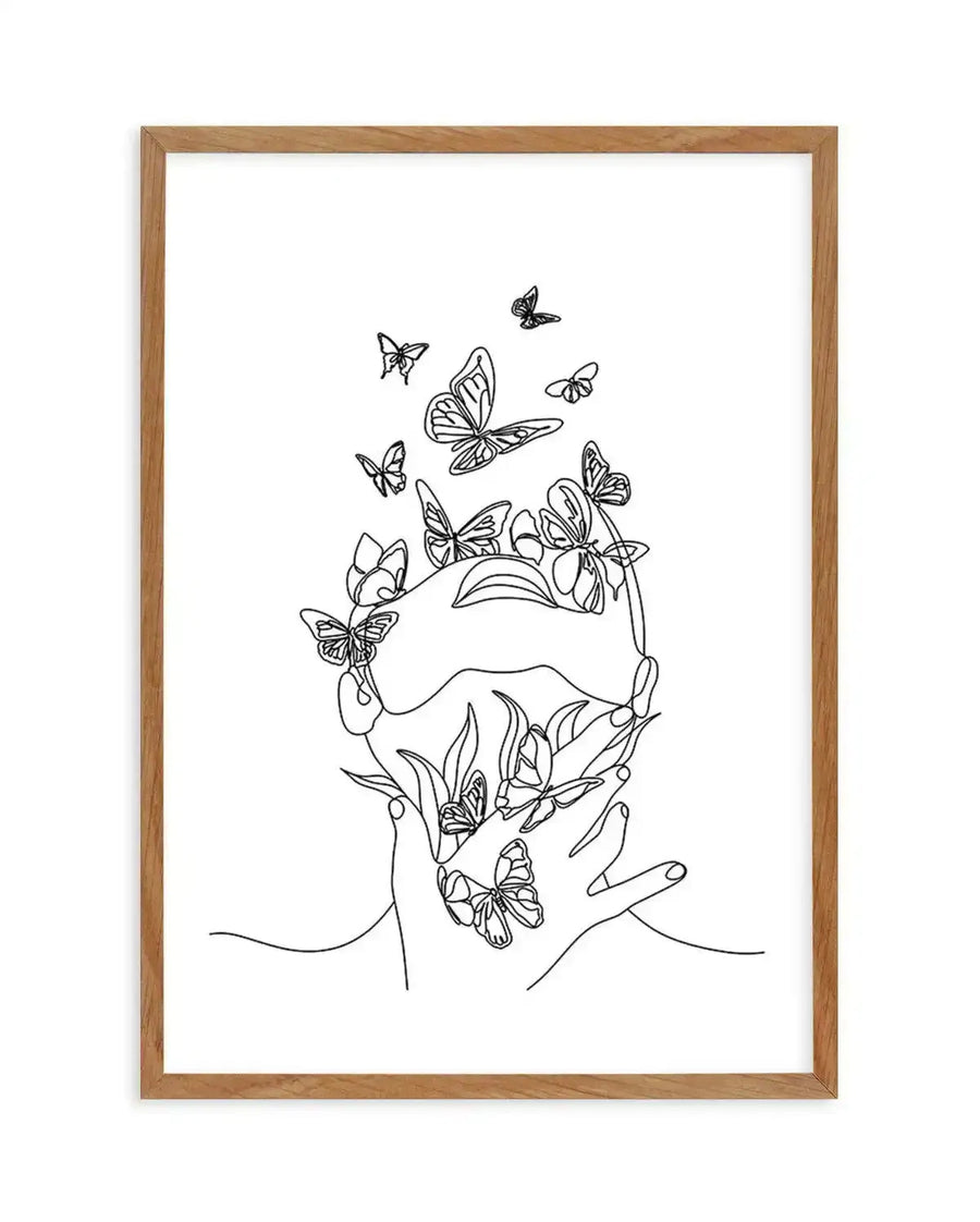 Line art print featuring a minimalist illustration of a person's face and hands, with numerous butterflies emerging from and surrounding their head and hands, displayed in a natural oak frame with white border. The continuous black line drawing depicts a serene profile, with butterflies of various sizes and wing patterns.
