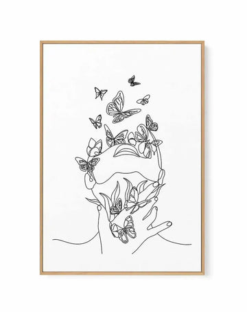 Framed canvas art print featuring a minimalist line drawing of a woman's face in profile, composed entirely of continuous black lines on a white background. Multiple butterflies and flowering plants emerge from the head, replacing the upper portion with botanical elements. Additional butterflies flutter above in varying sizes. The design is contained within a natural wood frame with a clean, simple aesthetic.