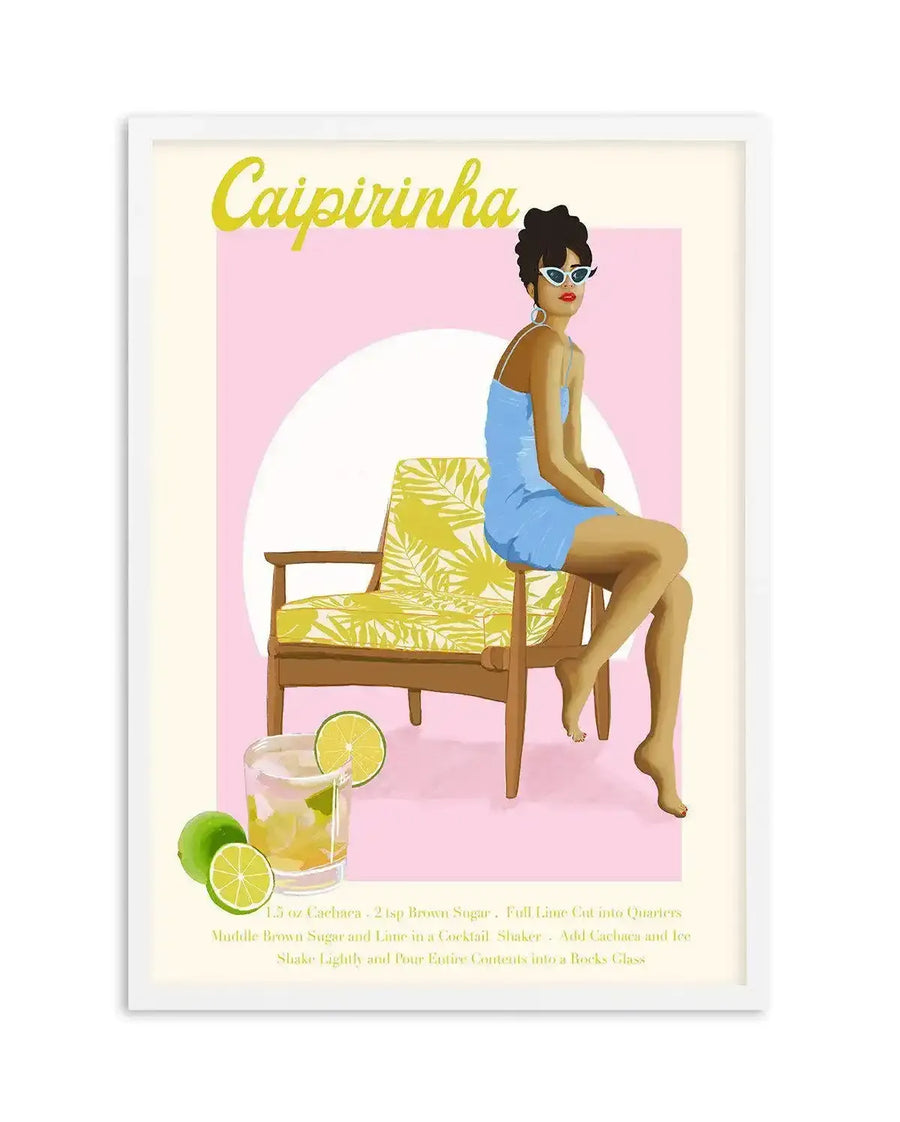 Art print featuring a retro-style illustration of a woman in a blue dress and white sunglasses sitting on a yellow and green patterned chair, against a pink background with a white circle. A glass of caipirinha with lime slices and whole limes is in the foreground, with the cocktail recipe written below in yellow text. The print is displayed in a white frame with a white border.