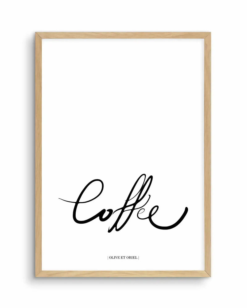 Framed art print featuring the word "Coffee" written in an elegant, flowing black script handwriting style against a white background. The design is centered in the lower portion of the print, with a small text credit line at the bottom. The artwork is displayed in a natural light wood frame with a white border.