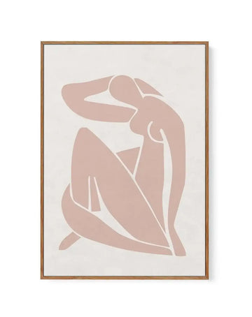 Framed canvas art print featuring an abstract female figure in minimalist style. The figure is rendered in soft dusty rose tones against a cream background, with white line work outlining the body's contours. The seated or crouching pose shows simplified, flowing forms suggesting the head, torso, arms, and legs. The design uses negative space and curved lines to create an elegant, contemporary aesthetic. Natural wood-toned frame with white border surrounding the canvas.