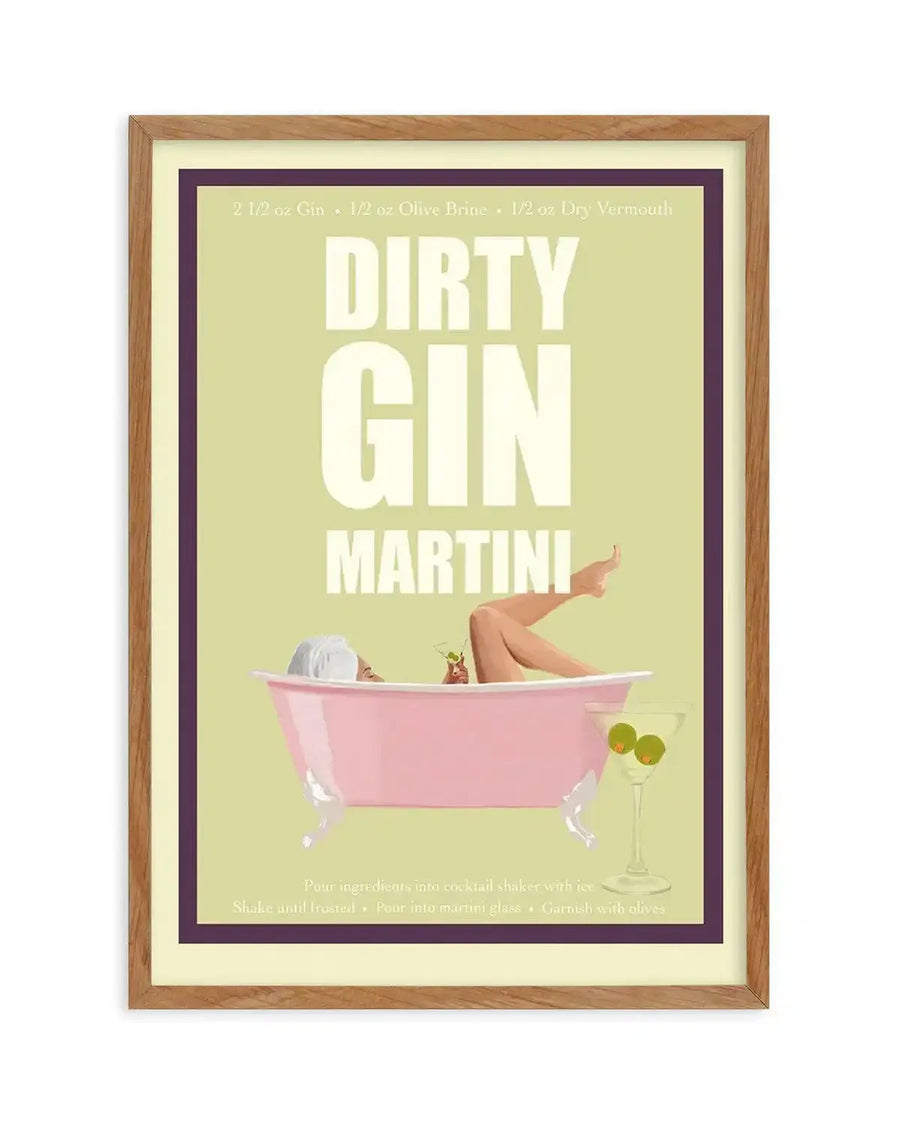 Art print featuring a retro-style illustration of a woman relaxing in a pink bathtub, holding a martini. The background is a light lime green with a dark purple border. Above the bathtub, the text "DIRTY GIN MARTINI" is displayed in large white letters. A martini glass with two olives sits on the side, and the recipe is listed at the top. The print is displayed in a natural oak frame with a white border.