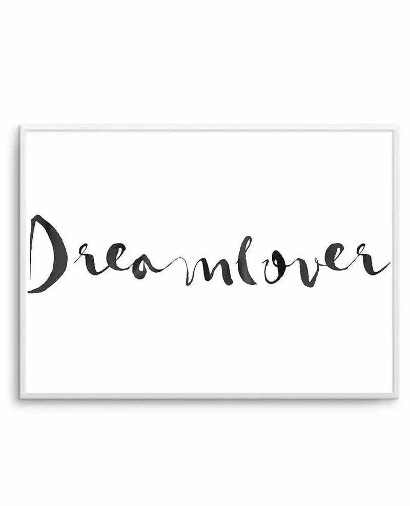 Framed art print featuring the word "Dreamlover" written in flowing, handwritten black script against a white background. The text has an organic, slightly irregular calligraphic style with varying line weights. The print is presented in a light gray frame with a white border.