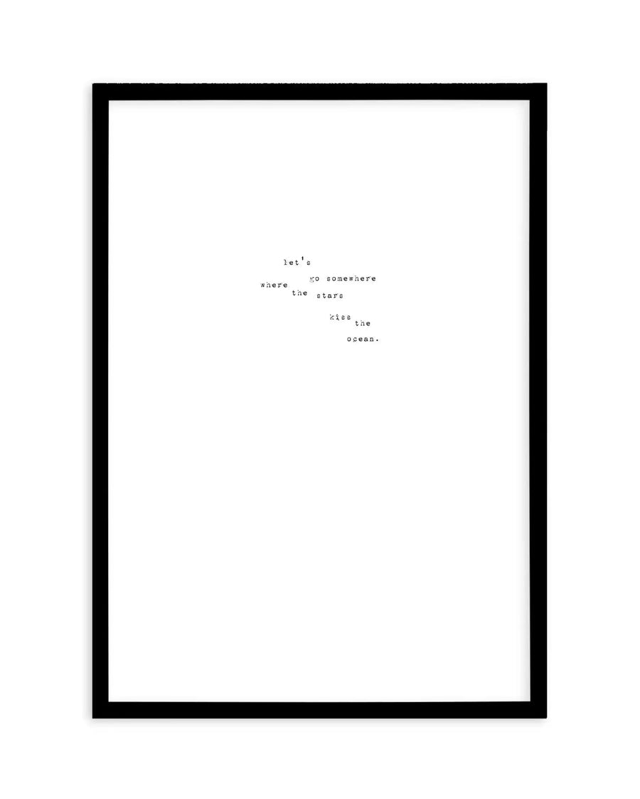 Art print with black frame featuring typewriter-style text in black on white background. The text reads "let's go somewhere where the stars kiss the ocean." arranged in a scattered, poetic layout across the center of the page. Simple, minimalist design with classic serif typeface suggesting a vintage aesthetic. White border visible between artwork and black frame.