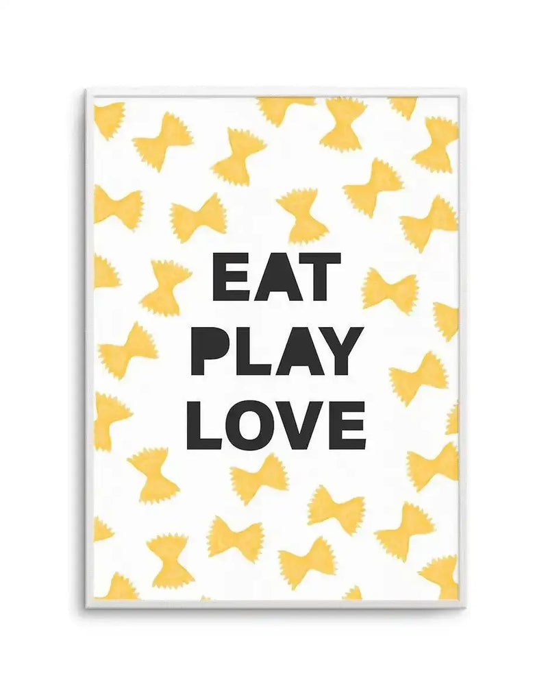 Framed art print featuring the text "EAT PLAY LOVE" in bold black letters centered on a white background. The design is surrounded by a scattered pattern of golden yellow bow-tie or pasta shapes in a flat illustration style. The artwork is displayed in a slim silver frame with a white border.