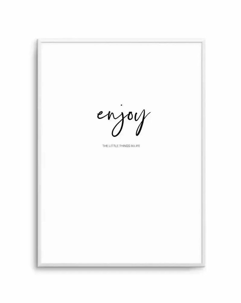Framed art print featuring handwritten-style black text reading "enjoy" in a flowing script, with smaller gray text below stating "THE LITTLE THINGS IN LIFE". Clean white background with a light gray wooden frame, displayed as a vertical rectangular print.