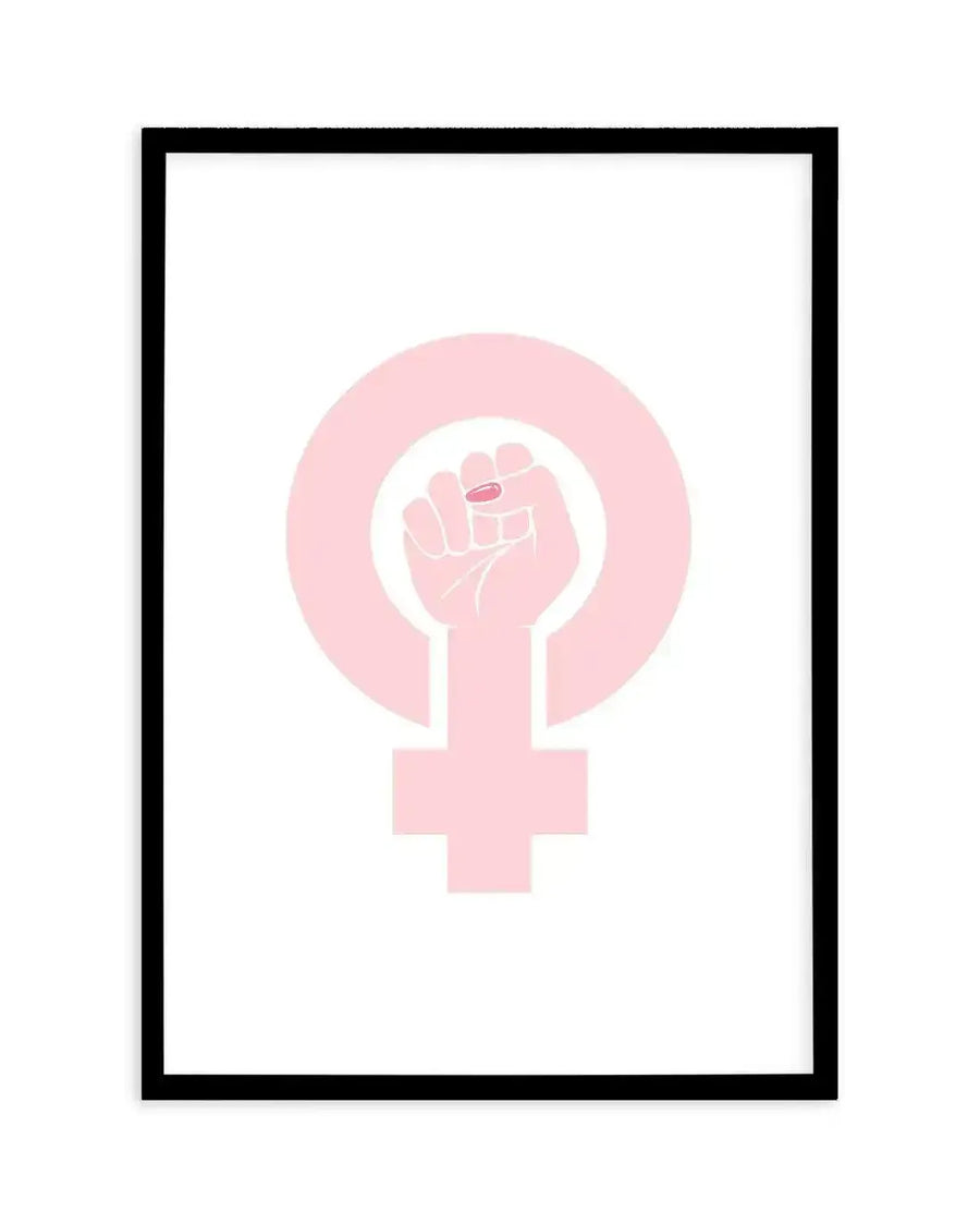 Art print featuring a pale pink female gender symbol with a raised fist in the center, displayed in a black frame with a white border. The fist has a small red detail on the thumb, suggesting a painted fingernail.