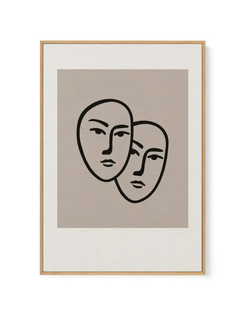 Framed canvas art print featuring two abstract faces in black outline on a warm greige background, with natural wood frame and white border. The faces are minimalist in style, with simple lines for eyes, nose, and mouth, overlapping slightly in the center.