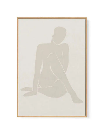 Framed canvas art print featuring a minimalist silhouette of a seated female figure in soft beige and cream tones against a light neutral background. The figure is shown in a contemplative pose with one leg extended and one bent. The artwork has a subtle, muted color palette with soft gradations creating depth. Displayed in a natural wood frame with a clean border.
