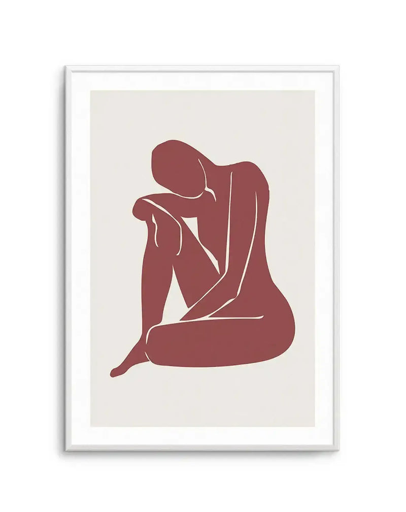 Minimalist art print featuring a seated female figure in a contemplative pose, rendered in a solid block of deep terracotta red with subtle white outlines defining the limbs. The figure is set against a warm off-white background and displayed in a white frame with a white border.