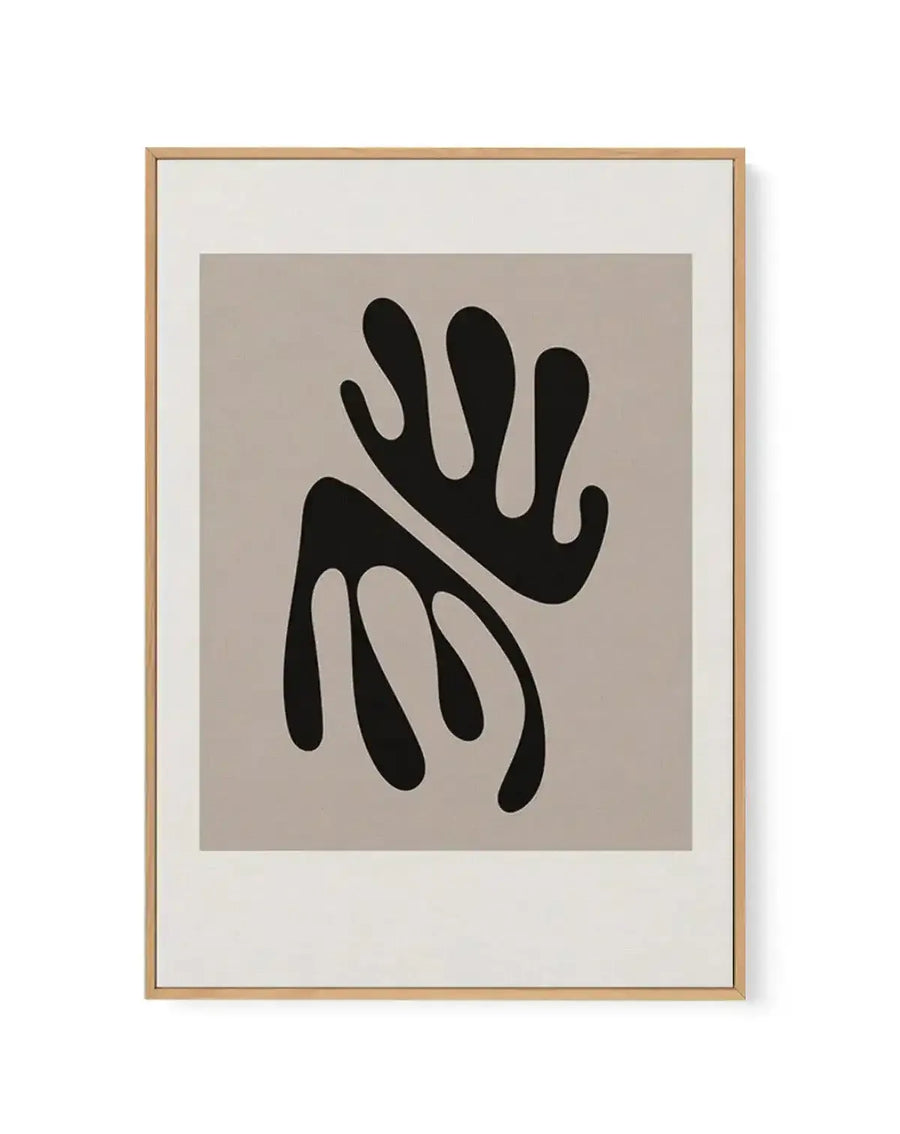 Abstract art print featuring two organic, blob-like shapes in solid black, one above the other and slightly overlapping, against a warm, light beige background. The shapes have rounded edges and a fluid, cut-out appearance. Printed on canvas and displayed in a natural oak frame with a white border.