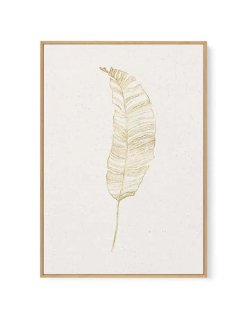 Gold Palm II framed canvas art print featuring a minimalist line drawing of a single palm leaf in muted gold tones on a cream background. The leaf is rendered with fine, delicate linework showing detailed vein patterns and natural curves. The artwork is displayed in a natural wood frame with a white border, mounted against a plain white background.