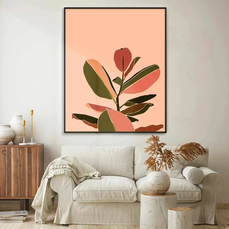Large framed art print displayed above a cream sofa in a minimalist living room. The print features an abstract illustration of a fig plant with large leaves in shades of deep olive green, muted terracotta, and blush pink against a soft peach background, with a black frame and no border. The room includes a wooden side table with white ceramic vases and gold candlesticks, and a cream throw draped over the sofa.
