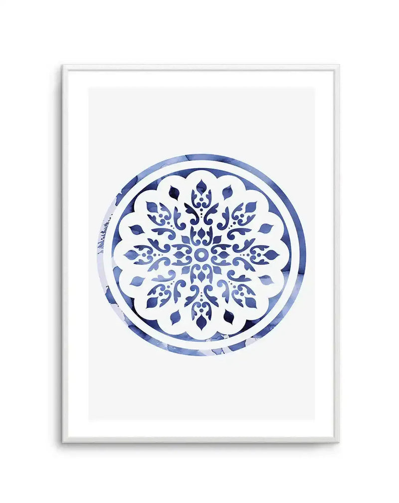 Watercolour art print featuring a circular mandala design with intricate floral and scrollwork patterns in varying shades of blue, from deep indigo to pale sky blue, on a white background. The design has a hand-painted, slightly textured quality, and is displayed in a white frame with a white border.