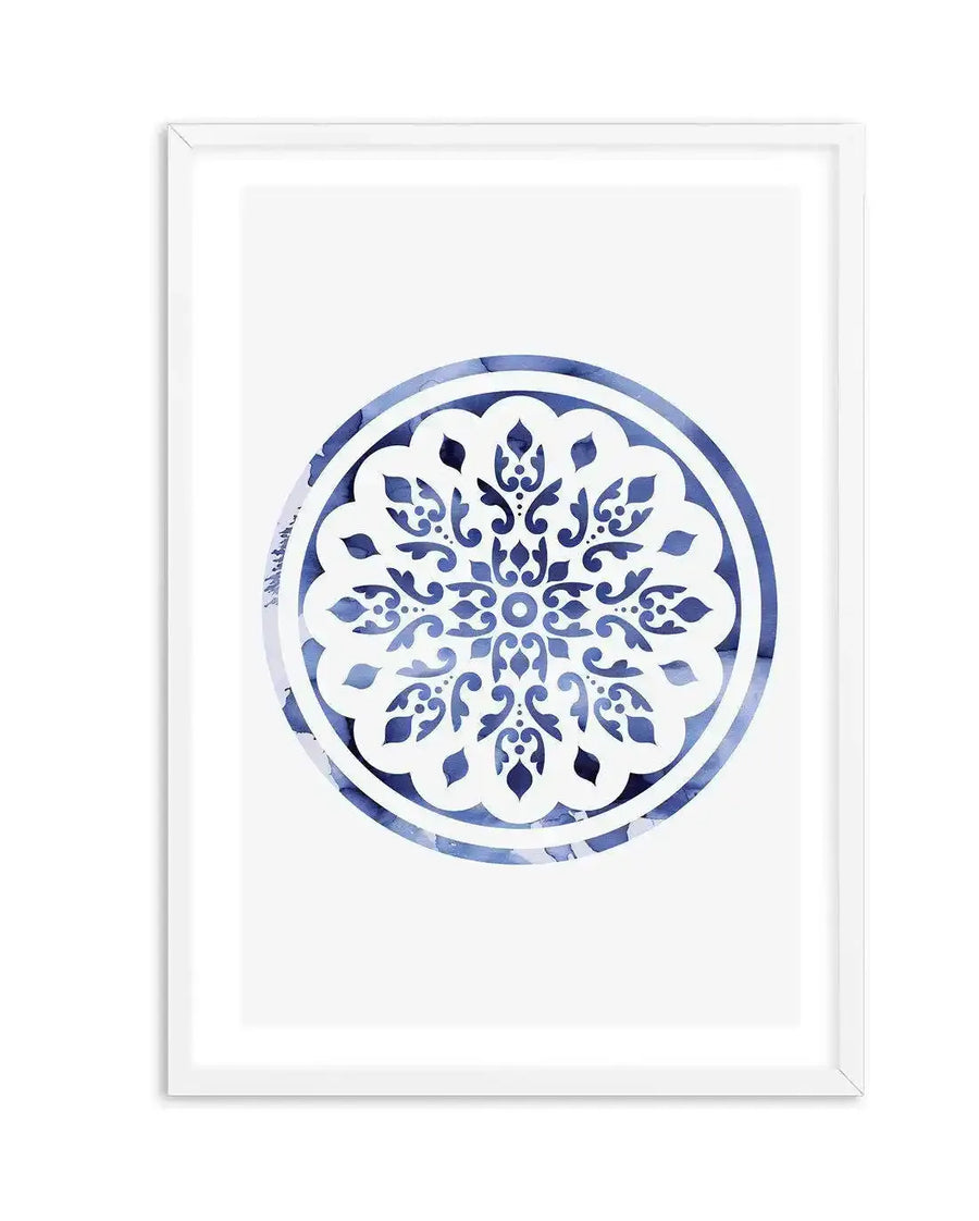 Abstract art print featuring a circular mandala design in deep indigo blue and white, with intricate symmetrical patterns and a watercolour texture, displayed in a white frame with white border.