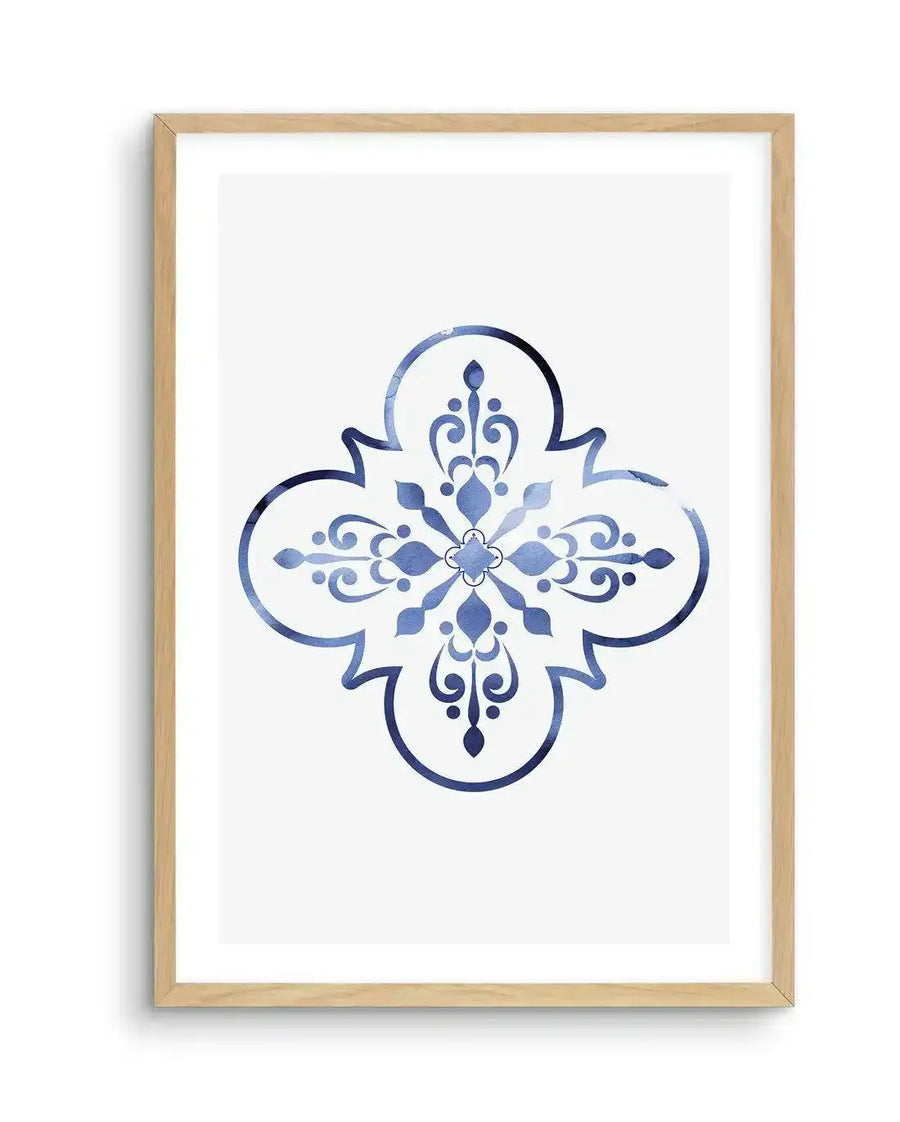 Watercolour art print featuring a symmetrical quatrefoil design in varying shades of blue, from deep navy to pale sky blue, with a distressed, textured finish, printed on fine art paper and displayed in a natural oak frame with white border.
