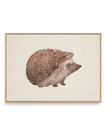 Watercolor illustration of a hedgehog in profile facing left, rendered in warm taupe and brown tones with detailed quill texture. The hedgehog is centered on a cream linen background. The artwork is presented in a natural wood frame with a white border, displayed against a plain white background.