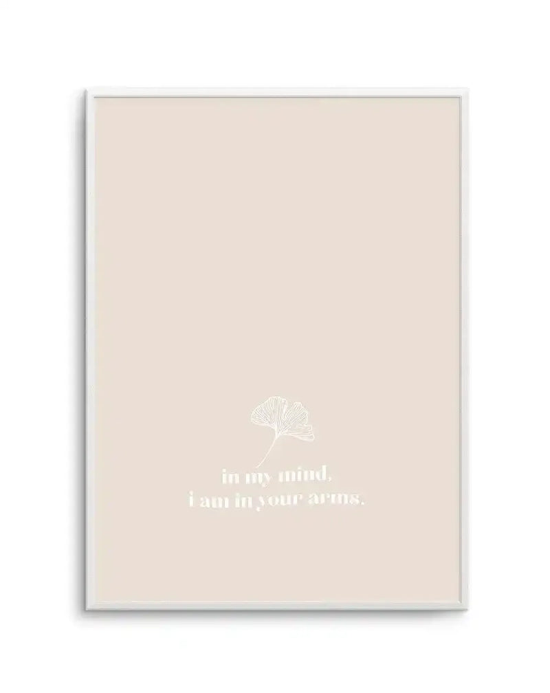 Framed art print on cream background featuring a delicate white line illustration of a ginkgo leaf in the center. Below the leaf, white serif text reads "in my mind, i am in your arms." in two lines. The print is housed in a light gray frame with white border. Minimalist aesthetic with soft, neutral color palette.