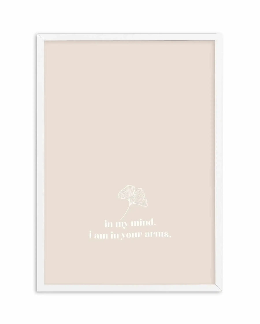 Framed art print with a cream beige background featuring a delicate white line-drawn ginkgo leaf illustration in the center-upper area. Below the leaf, white serif text reads "in my mind. i am in your arms." The artwork is presented in a white wooden frame with a subtle 3D beveled edge detail.