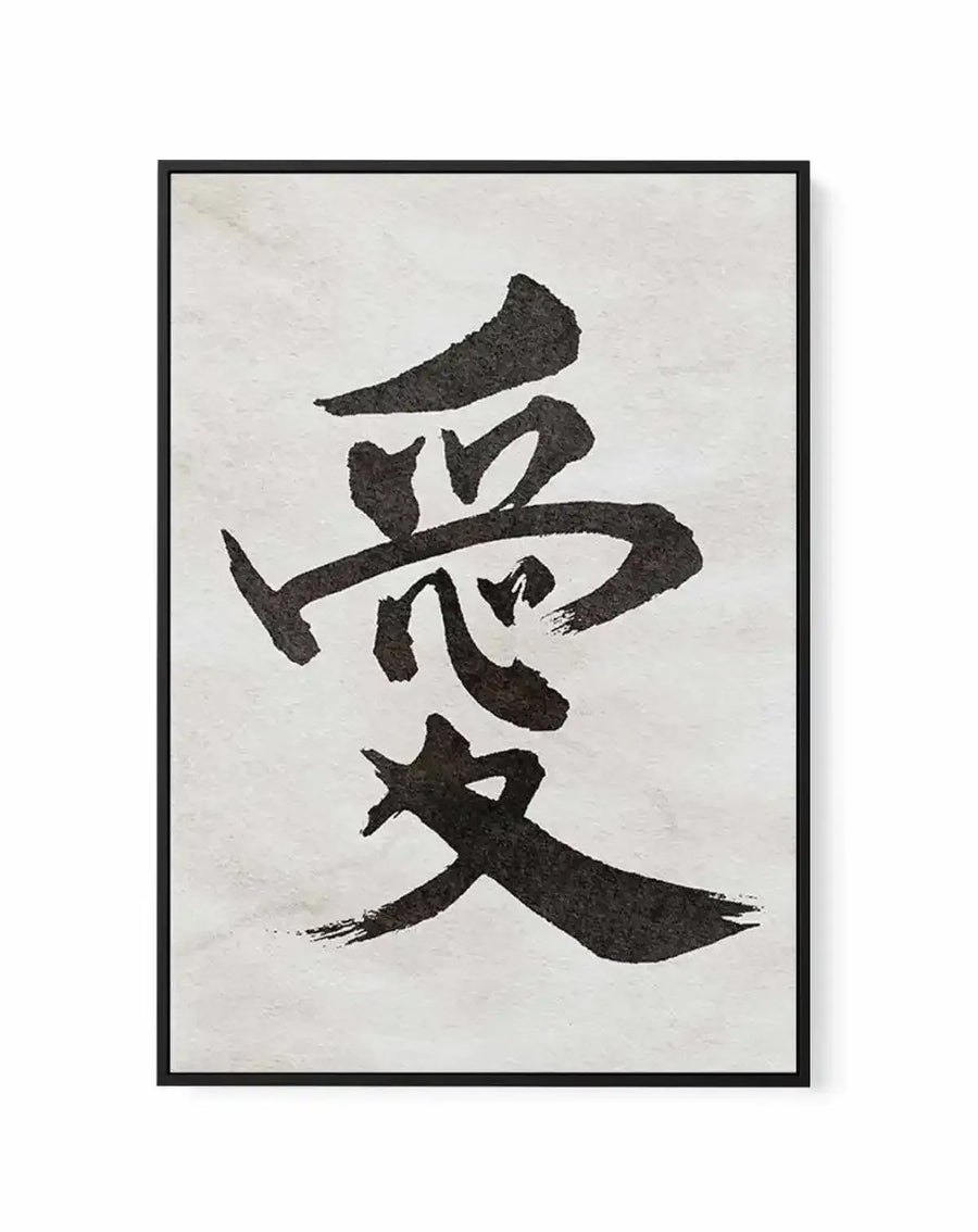 Framed canvas art print displaying Japanese calligraphy characters in black ink brush strokes on a cream-colored background. The characters are arranged vertically and represent the word "love." The strokes are bold and gestural with visible texture from the brushwork. The canvas is mounted in a black wooden frame with clean edges. The overall composition has a minimalist, contemporary aesthetic against the neutral off-white canvas surface.