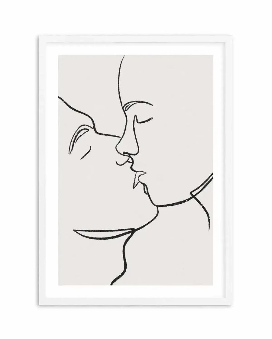 Line art print featuring two faces in profile, almost touching in a kiss, rendered in a single continuous black line with a subtle textured, grainy appearance on a light cream background, displayed in a white frame with a white border.