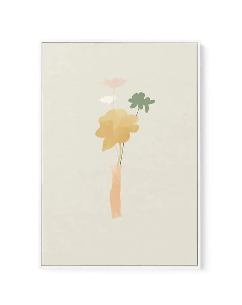 Framed canvas art print featuring a minimalist watercolor illustration of three delicate flowers in a peach-toned vase against a soft cream background. The composition includes a large golden-yellow bloom on the left, a small pink flower at top center, and a dark green clover-like leaf on the right, connected by thin green stems. The artwork has a soft, ethereal quality with muted, naturalistic colors. The canvas is surrounded by a thin gray frame with a white border.