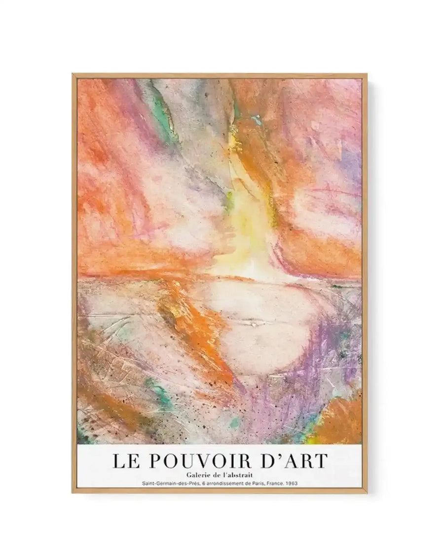 Abstract canvas print featuring a dynamic composition of vibrant, expressive brushstrokes in warm oranges, pinks, yellows, and purples, with hints of green and blue, creating a textured, almost luminous effect. The artwork is displayed in a natural wood frame with a white border at the bottom containing text.