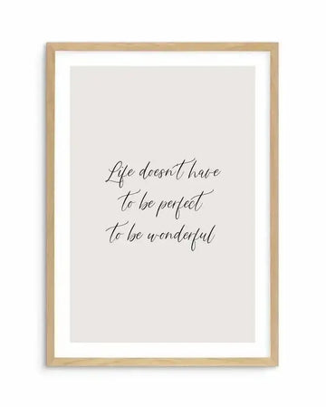 Art print featuring the handwritten quote "Life doesn't have to be perfect to be wonderful" in black script on a light grey background, displayed in a natural oak frame with white border.