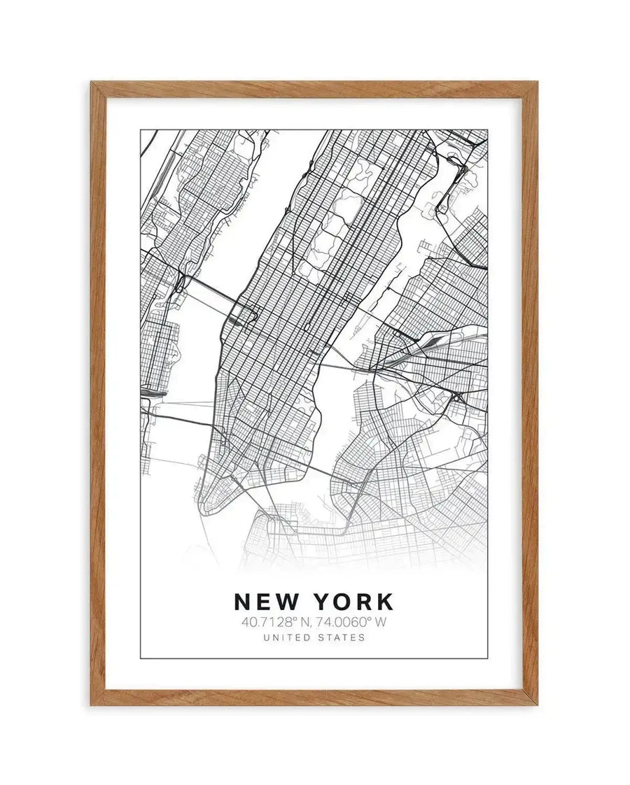 Line art map print of New York City, featuring a detailed street grid and waterways in black on a white background, printed on fine art paper and displayed in a natural oak frame with white border. The print includes text at the bottom: "NEW YORK 40.7128° N, 74.0060° W UNITED STATES".