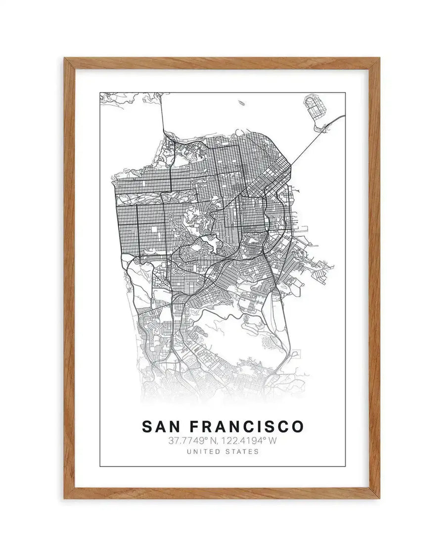 Line art map print of San Francisco, featuring a detailed street grid in black lines on a white background, printed on fine art paper and displayed in a natural oak frame with white border. The print includes the text "SAN FRANCISCO" and its coordinates "37.7749° N, 122.4194° W UNITED STATES" at the bottom.