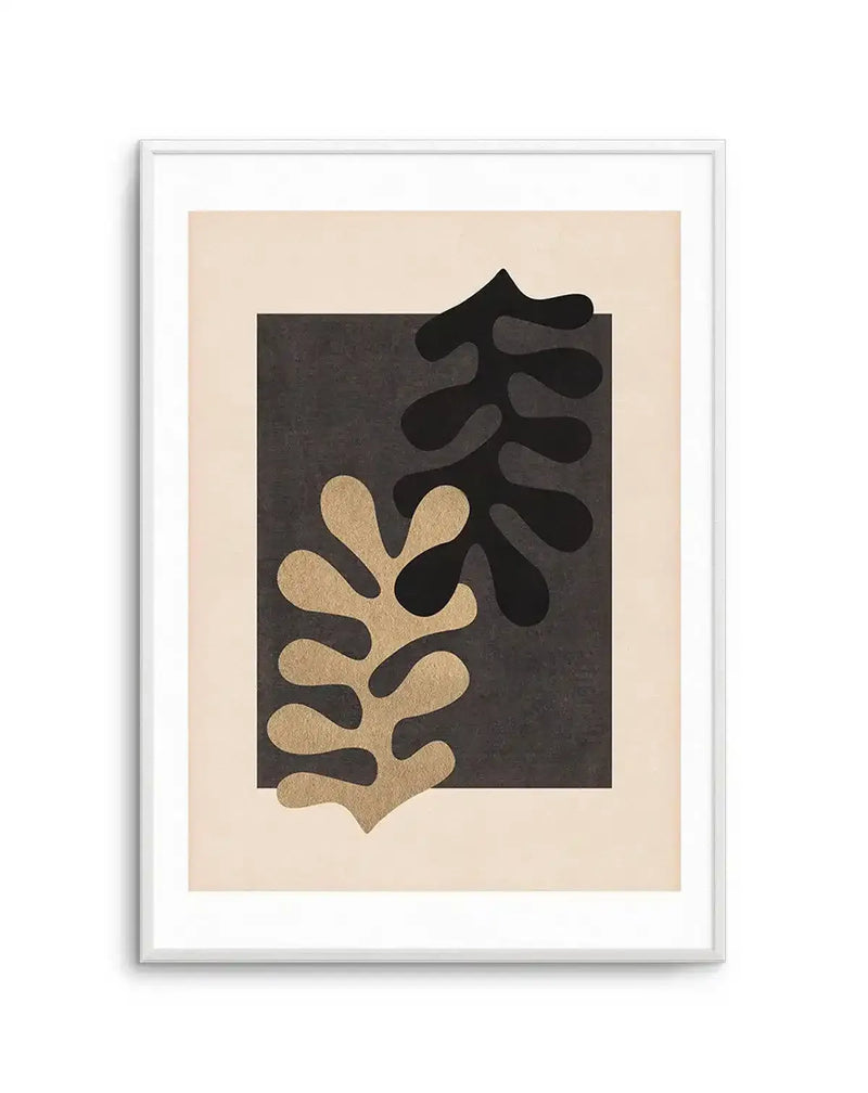 Abstract art print featuring two overlapping organic leaf shapes in black and metallic gold against a dark charcoal grey square, set on a light beige background, displayed in a white frame with a white border.