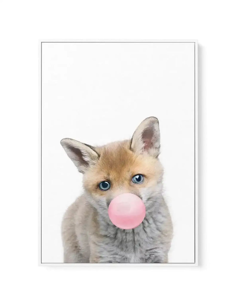 Canvas art print featuring an illustration of a young fox with tan and cream-colored fur and bright blue eyes, blowing a large bubble gum bubble in soft pink. The fox is centered against a clean white background, rendered in a realistic watercolor style. The canvas is framed with a thin gray border and mounted on a white wall, creating a minimalist, whimsical composition suitable for nursery or contemporary home décor.