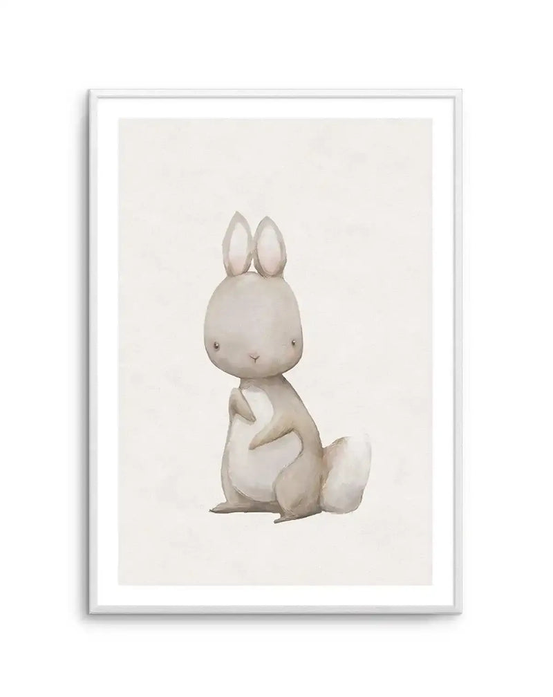 Watercolour art print featuring a sweet, plump little rabbit with long ears and a fluffy white tail, rendered in soft grey and cream tones with gentle brushstroke detail, displayed in a white frame with white border.