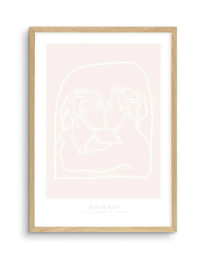 Line art print featuring two figures kissing, outlined in white against a pale pink background, with the text "love is love" in white at the bottom, displayed in a natural oak frame with white border.