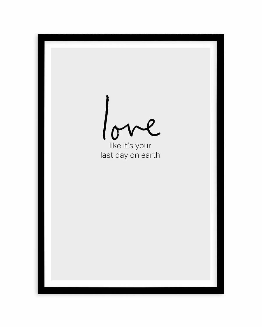 Framed art print with black frame and white border featuring minimalist typography on light gray background. The word "love" appears in handwritten-style black script, larger than the smaller printed text below it reading "like it's your last day on earth" in sans-serif font. The composition is centered and clean, evoking an inspirational, contemplative mood through simple typography and neutral color palette.