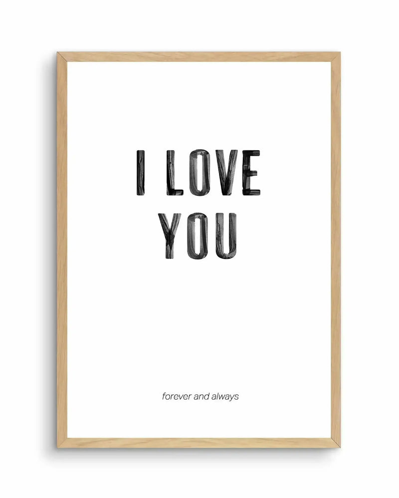 Framed art print with natural wood frame displaying black hand-drawn lettering reading "I LOVE YOU" centered on a white background, with smaller italicized text reading "forever and always" positioned below. The letters have a rough, sketched texture with visible line work. The overall composition is simple and minimalist with generous white space surrounding the text.