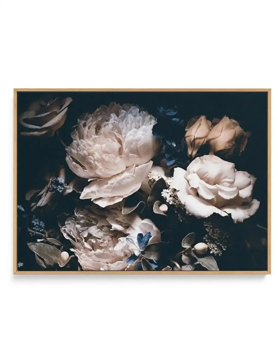 Framed canvas art print titled Midnight Botanica LS featuring a dark teal background with a detailed botanical arrangement of pale blush and cream peonies, roses, and smaller tan buds. Delicate blue butterflies and wispy baby's breath flowers accent the composition. The canvas is mounted in a natural wood frame with a white border, creating a classic gallery-style presentation.