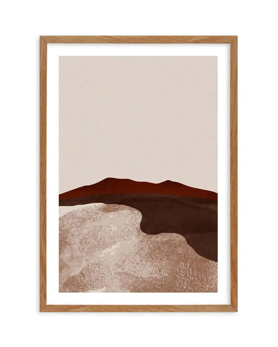 Abstract art print featuring a minimalist desert landscape with a deep reddish-brown mountain range under a pale beige sky. Below the mountains, a textured, wavy expanse of light beige and warm brown suggests sand dunes, displayed in a natural oak frame with white border.