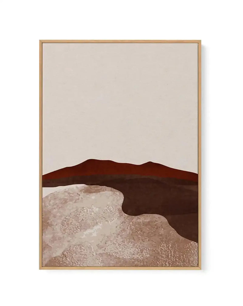 Abstract canvas print featuring a minimalist desert landscape with a deep reddish-brown mountain range against a pale cream sky, above a textured foreground of light beige and dark brown shapes, displayed in a natural wood frame.