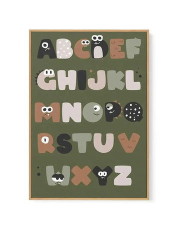 Framed canvas art print featuring an illustrated alphabet on a sage green background. Each letter from A to Z is designed as a friendly monster character with googly eyes and simple facial features in shades of cream, tan, brown, and black. The letters are arranged in five rows across the canvas. The print is mounted in a natural wood frame with a white border.
