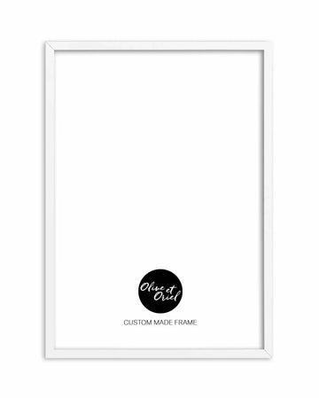 White wooden frame with clean lines and slight depth, displaying a blank white interior space with a thin white border. At the bottom center, a black circular logo contains white handwritten text reading "Olive et Oriel" with the text "CUSTOM MADE FRAME" printed below in black sans-serif font. The frame is photographed against a white background, showing its simple, minimalist design suitable for displaying artwork or prints.