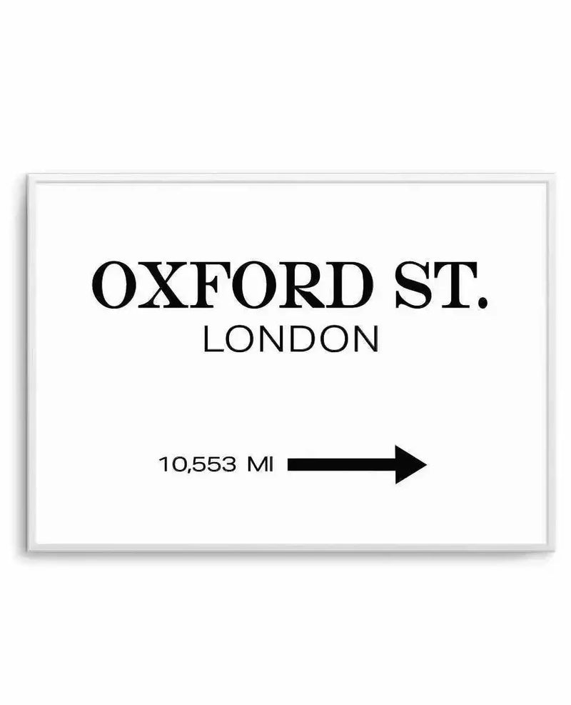 Art print featuring the bold black text "OXFORD ST." above "LONDON" in a smaller font, with "10,553 MI" and a black arrow pointing right below, all on a clean white background, displayed in a white frame.