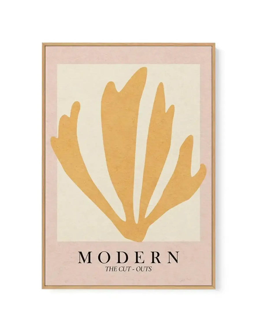 Framed canvas art print titled "Modern The Cut-Outs" featuring an abstract composition of five golden-yellow organic shapes arranged in a fan or hand-like formation against a cream background. The artwork is mounted in a natural wood frame with a dusty rose-pink border. The style is minimalist and contemporary with clean, cut-out paper aesthetic. The frame has visible wood grain and a subtle shadow effect showing depth against a white background.