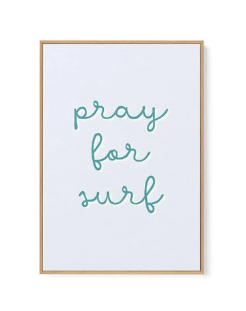 Framed canvas art print featuring handwritten script text reading "pray for surf" in teal green cursive lettering on a white background. The canvas is set in a natural wood frame with a thin border. The flowing, casual script has organic loops and curves, creating a relaxed, coastal-inspired aesthetic.