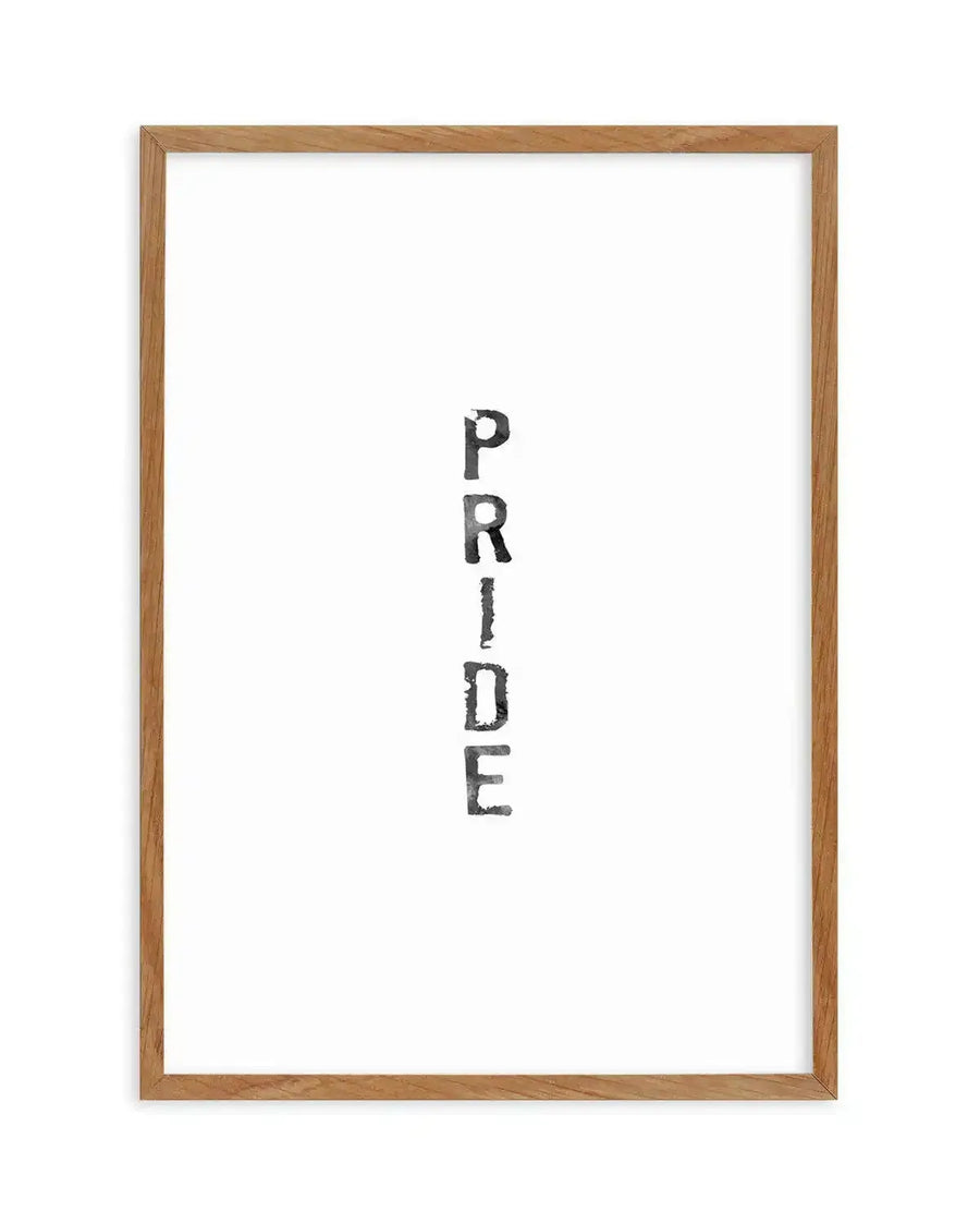 Watercolour art print featuring the word "PRIDE" stacked vertically in black, distressed, block letters against a stark white background, printed on fine art paper and displayed in a natural oak frame with white border.