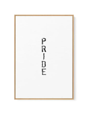 Framed canvas art print featuring the word "PRIDE" written vertically in black watercolour lettering with a textured, hand-drawn appearance on a white background. The canvas is set in a natural wood frame with a white border, displayed against a plain background with subtle shadow detail visible on the right edge.