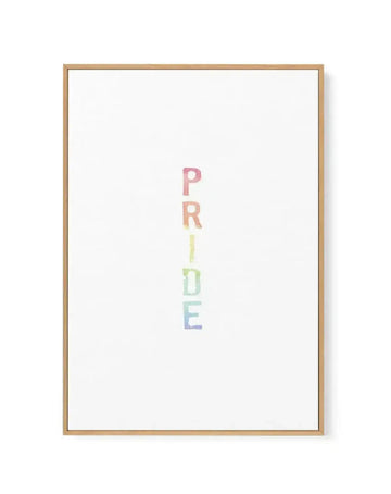 Framed canvas art print featuring the word "PRIDE" written vertically in center composition. Each letter is rendered in watercolour with a gradient rainbow effect, transitioning from pink at top through coral, yellow, green, to blue at bottom. White background with natural wood frame and thin wooden border visible around edges.